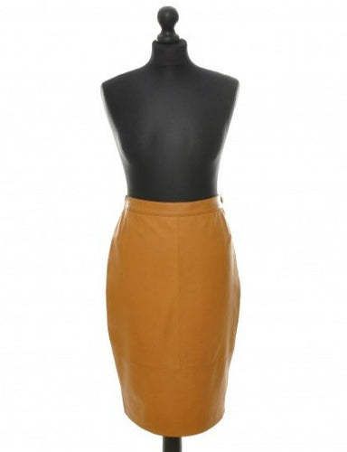 Camel color, midi-length, sheep leather skirt with a fitted silhouette, invisible zipper and vent at the back, displayed on a black mannequin.