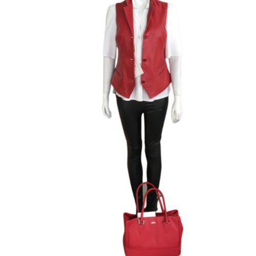 A mannequin displaying a red color short length crumpled sheep leather vest with a round neckline, half shank at the front, and pockets. It is worn with a white shirt and black pants.
