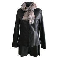 A black leather jacket with a stand collar and front pockets, displayed on a mannequin with a grey scarf wrapped around the neck.