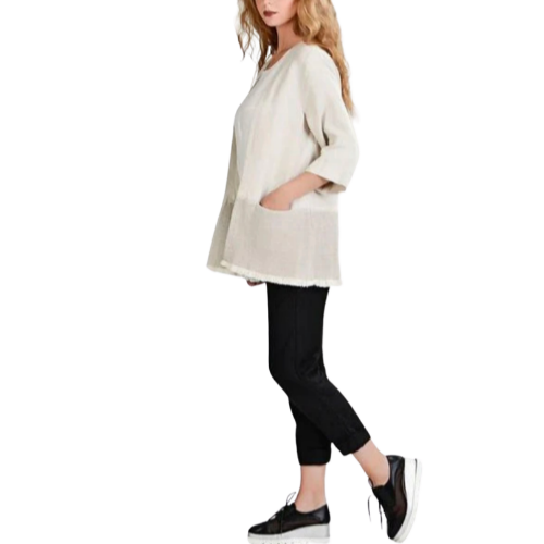 A woman wearing a beige linen loose mid length cardigan with 3/4 sleeves, paired with black pants and black shoes.