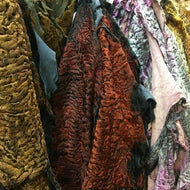 Colorful Astrakhan pelts from Vilniaus Kailiai, showcasing luxurious Karakulio kailis fur with a vibrant, textured appearance.